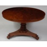 A William IV mahogany breakfast table, the circular tilt-top on a tulip carved column to platform