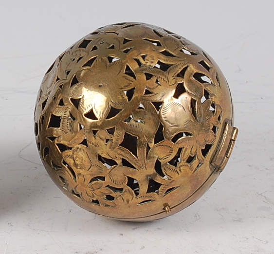 An early 19th century pierced and engraved brass incense ball, decorated as flowers and foliage,