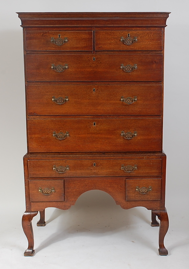 A George III oak chest-on-stand, having a cavetto cornice over two short and three long drawers, the