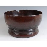 A turned elm bowl, of good size, raised on four small pad feet, probably first half 18th century,