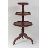 A Scottish Regency mahogany pedestal dumb-waiter, having three graduated galleried tiers on flaring,