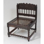 A Ceylon relief carved calamander nursing chair, having drop in cane seat, with spiral turned