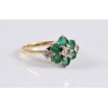 An 18ct emerald and diamond cluster ring, the central round brilliant cut diamond, surrounded by