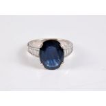 An 18ct sapphire and diamond ring, the oval sapphire, approx. 10.1 x 12.9 x 4mm, in four double