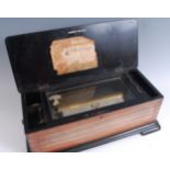 A late 19th century Swiss music box, the rosewood inlaid case decorated with musical instruments,