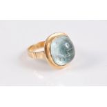 An aquamarine ring, the off round aquamarine cabochon, collet mounted with outer border, approx. 7 x