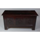 *An 18th century joined oak coffer, the two-plank top on split ring hinges, above a carved three