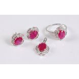 A 9ct ruby and diamond suite, the ring set with an oval ruby in a four claw mount, surrounded by