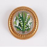 A late 19th century rock crystal painted brooch, the oval rock crystal cabochon painted with lilly