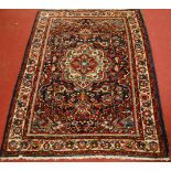 A Persian woollen Tafresh rug, having a floral decorated blue ground within trailing tramline