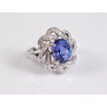 A 14ct tanzanite and diamond ring, the oval tanzanite, approx. 8.8 x 10.9mm, in a four claw mount,