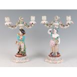 A pair of continental porcelain two-light candelabra, modelled as a young huntsman and his maiden