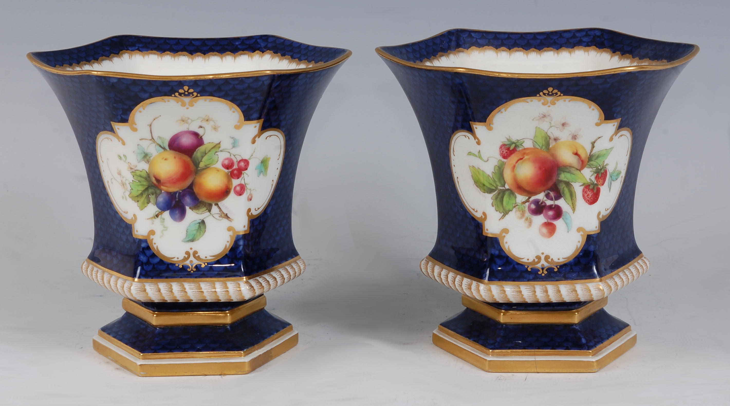 *A pair of Royal Worcester porcelain vases, each of waisted hexagonal form, the central reserve