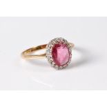 An 18ct pink sapphire and diamond ring, the oval pale raspberry pink sapphire, approx. 9.1 x 7.5 x