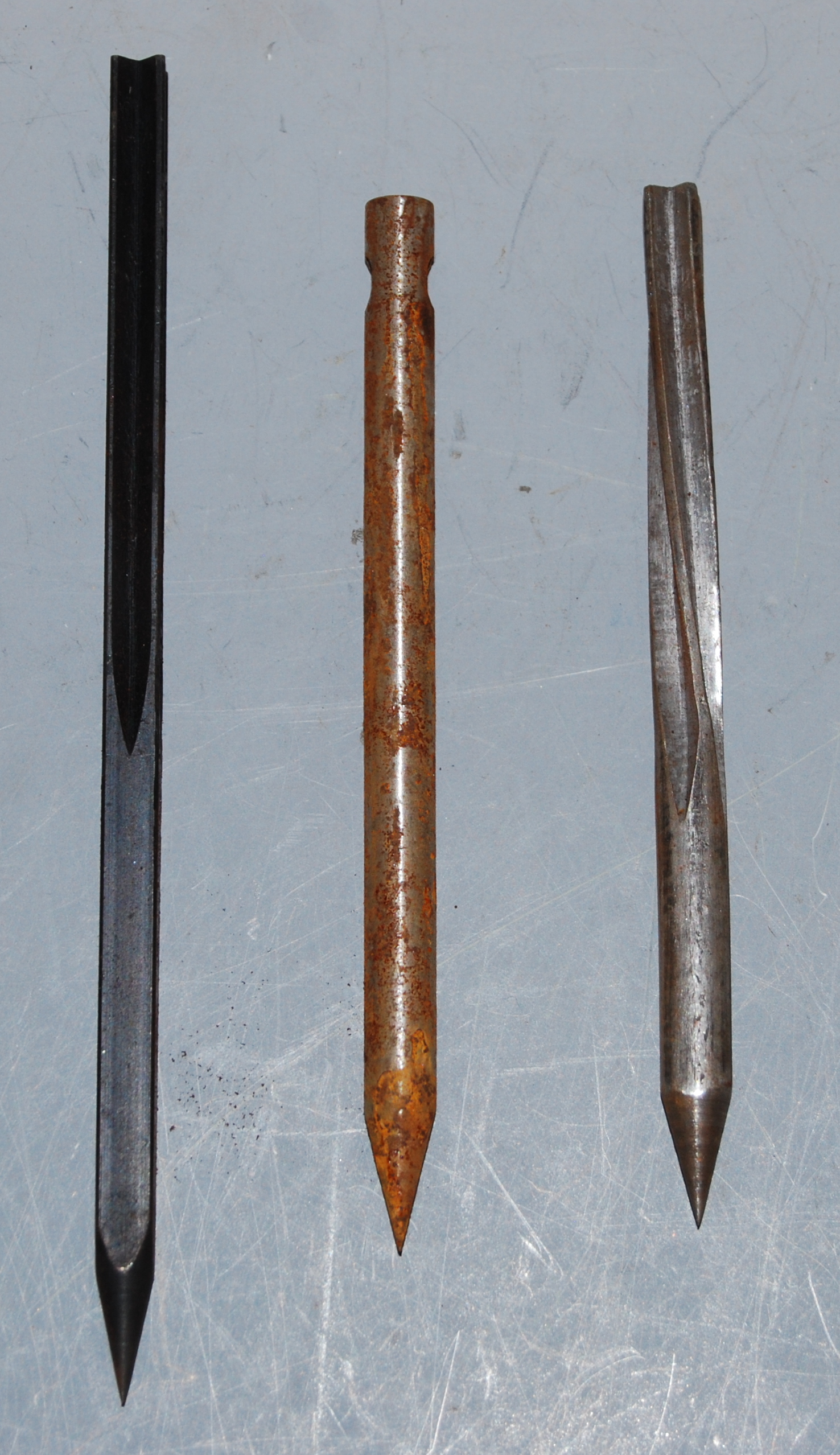 A collection of three various flechette darts