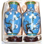 A pair of Japanese cloisonné vases, of baluster form, typically decorated with flowers, with pierced
