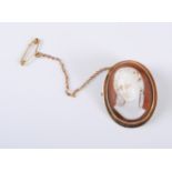 An oval shell cameo of a lady with upswept hair, collet mounted with milligrain border, all in