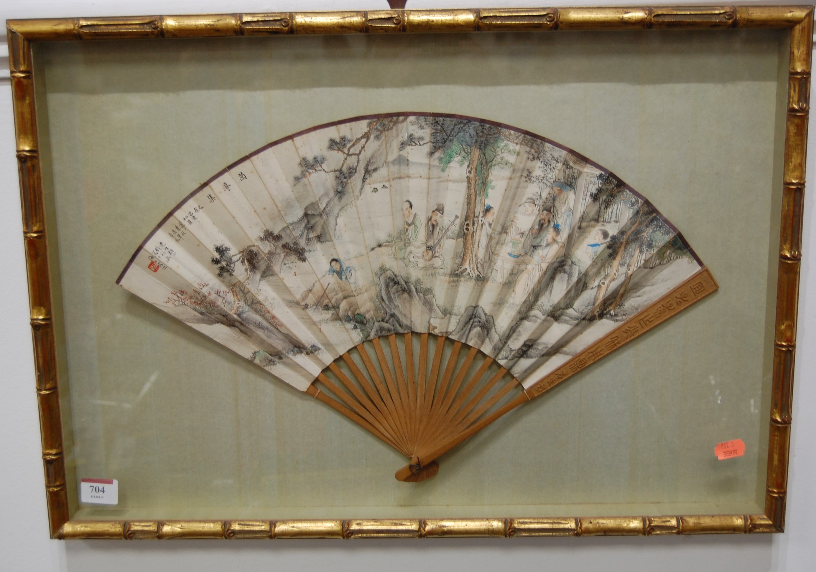 A mid-20th century hand-decorated Japanese fan, having Japanese script and depicting a dining/