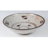 A large studio pottery glazed circular table bowl, in the manner of Bernard Leach, leaf decorated