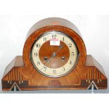 An Art Deco walnut cased mantel clock, having a silvered dial with Arabic numerals, and eight day