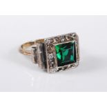 A 9ct gold and silver Art Deco style ring, the central green paste surrounded by a border of small