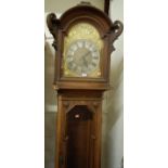 A circa 1900 Continental geometric moulded oak longcase clock, having an arched brass and silvered