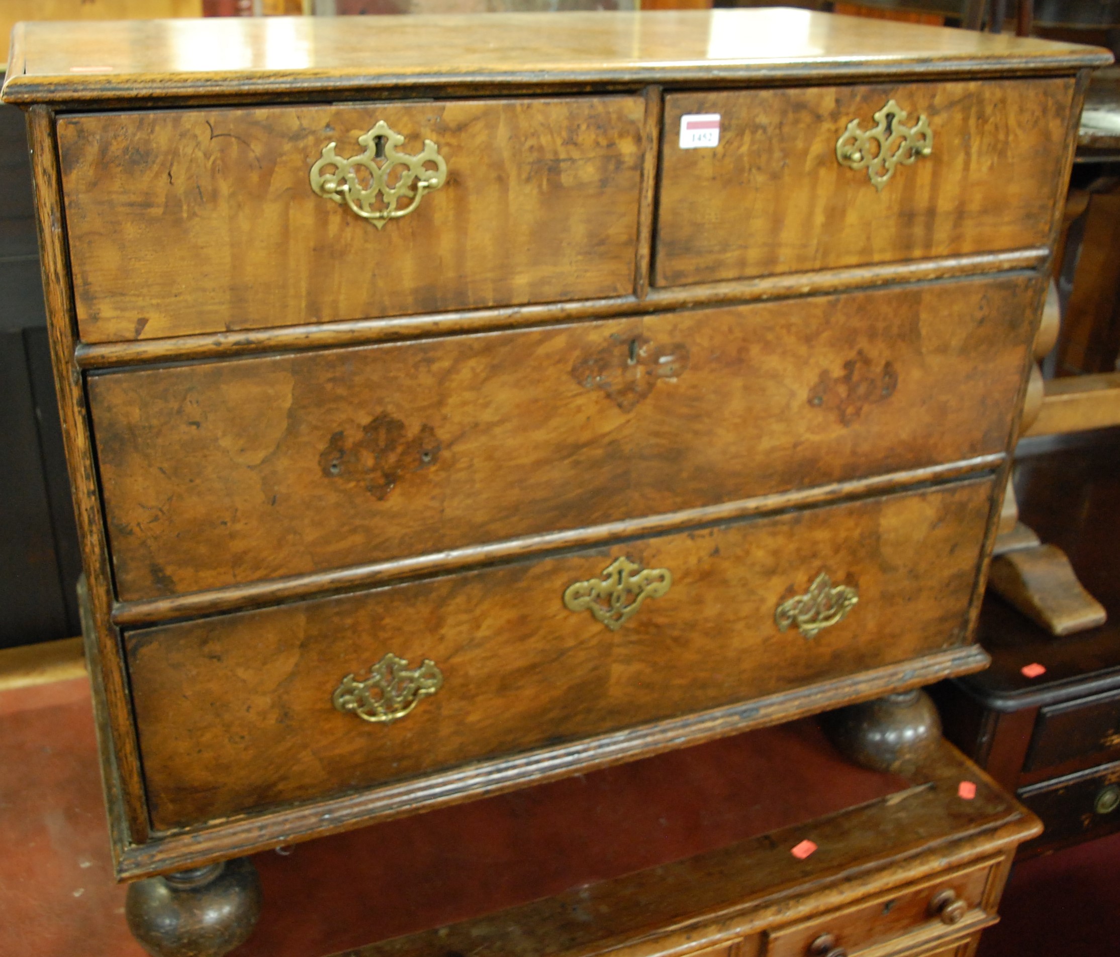 A WIlliam & Mary style figured walnut low chest of two short over two long drawers, raised on bun
