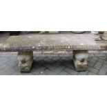 A reconstituted stone low garden bench seat, having egg and dart moulded edge, raised on recumbent