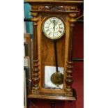 A late 19th century figured walnut Vienna drop trunk wall clock, having central white enamel dial,