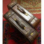 A pair of 1970s tan leather suitcases, with brass hardware