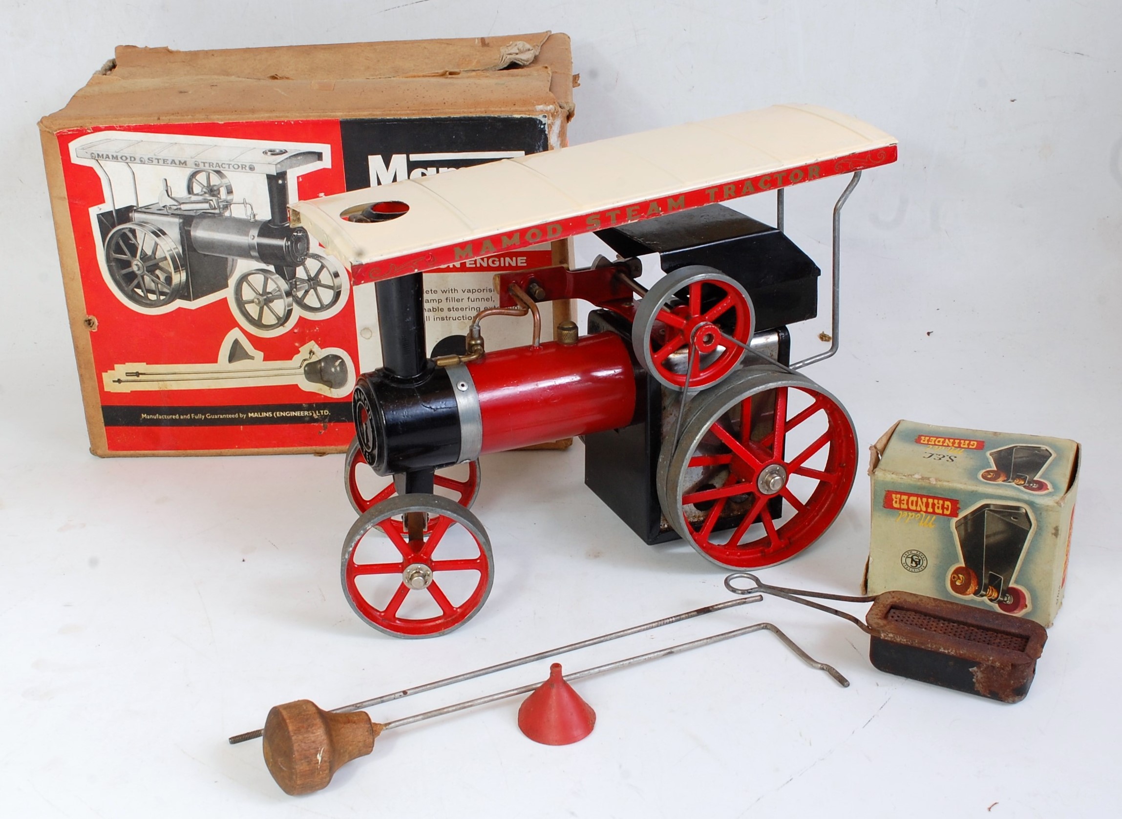 A Mamod TE1 traction engine finished in red with original canopy, steering rod, scuttle, and burner,