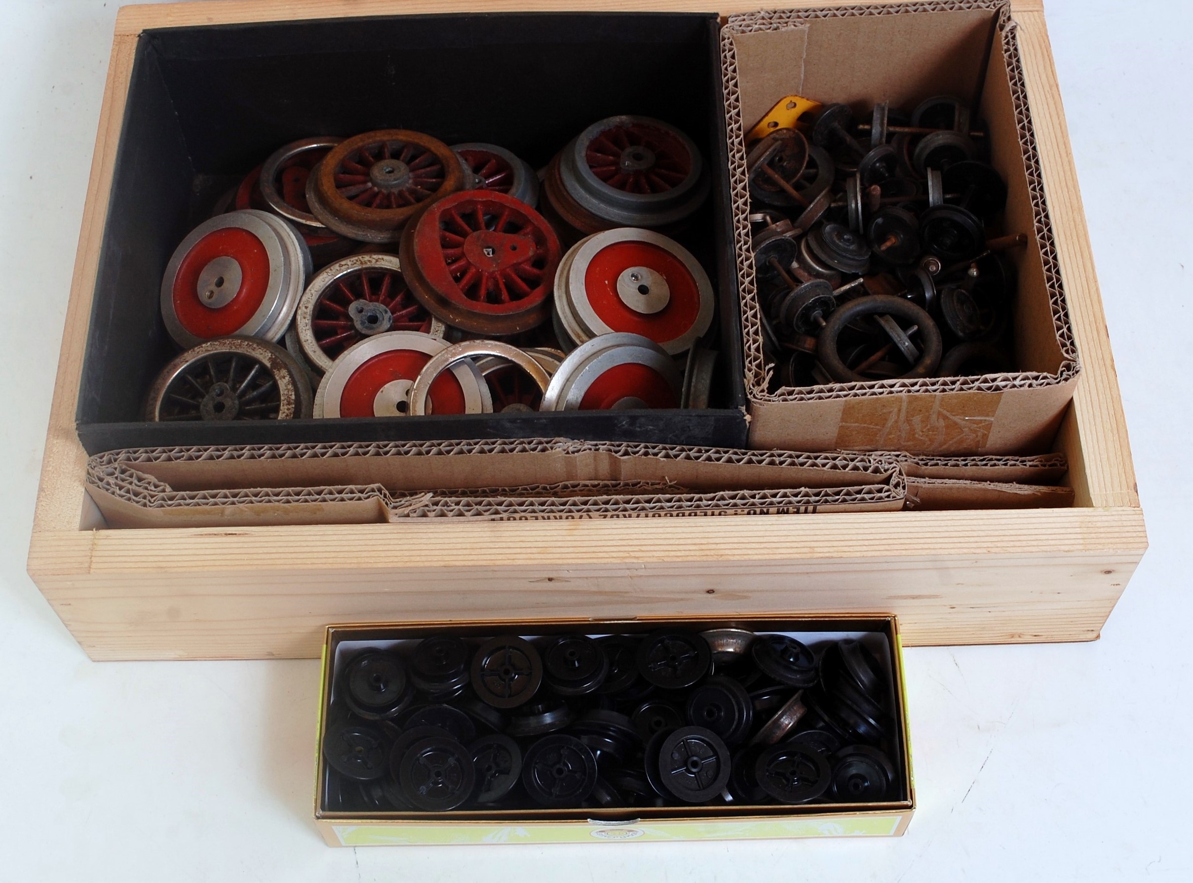 A small wooden box of assorted wheels of various gauges including Lionel and Hornby as removed