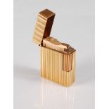 A gilt metal lighter by Dupont, the rectangular lighter with vertical ridges and flip top lid,