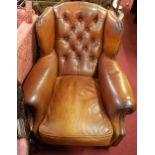 A good contemporary tan leather buttonback and brass studded wingback scroll club armchair, raised