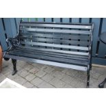 A Victorian style black painted, pierced cast iron ended and wooden slatted two seater garden bench,