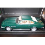 A 1/18 scale boxed model of a 1977 Aston Martin V8 Vantage finished in metallic green (missing one