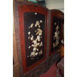 An early 20th century Japanese floral relief carved framed two division dressing screen, each