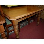 A late Victorian oak extending dining table, the moulded edge with canted corners, pull-out