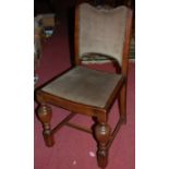 A set of four 1930s moulded oak dining chairs, having green upholstered studded pad backs and