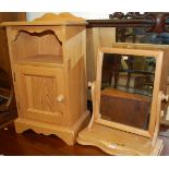 A modern pine ledgeback single door bedside cupboard, together with a pine swing toilet mirror (2)