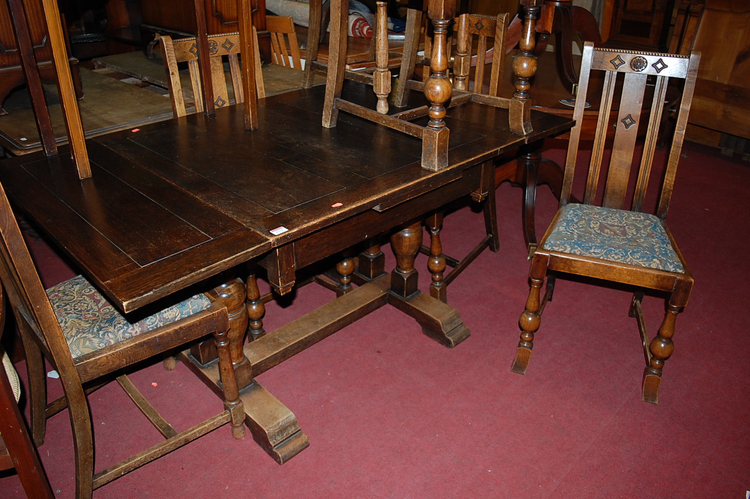 A 1930s oak drawleaf dining table, max. length 152cm; together with a set of six oak slatback dining