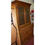 A mid-Victorian figured walnut bookcase cupboard, having double door glazed upper section over