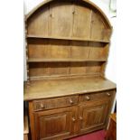 An oak dome topped dresser, having twin linenfold panelled lower cupboard doors, width 136.5cm