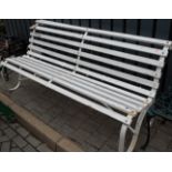 A 19th century white painted wrought iron framed and wooden slatted four seater garden bench,