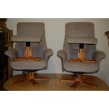 A pair of contemporary upholstered swivel armchairs, each with matching footstools, width 77cm