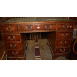 A reproduction mahogany gilt tooled green leather inset twin pedestal writing desk, w.121.5cm