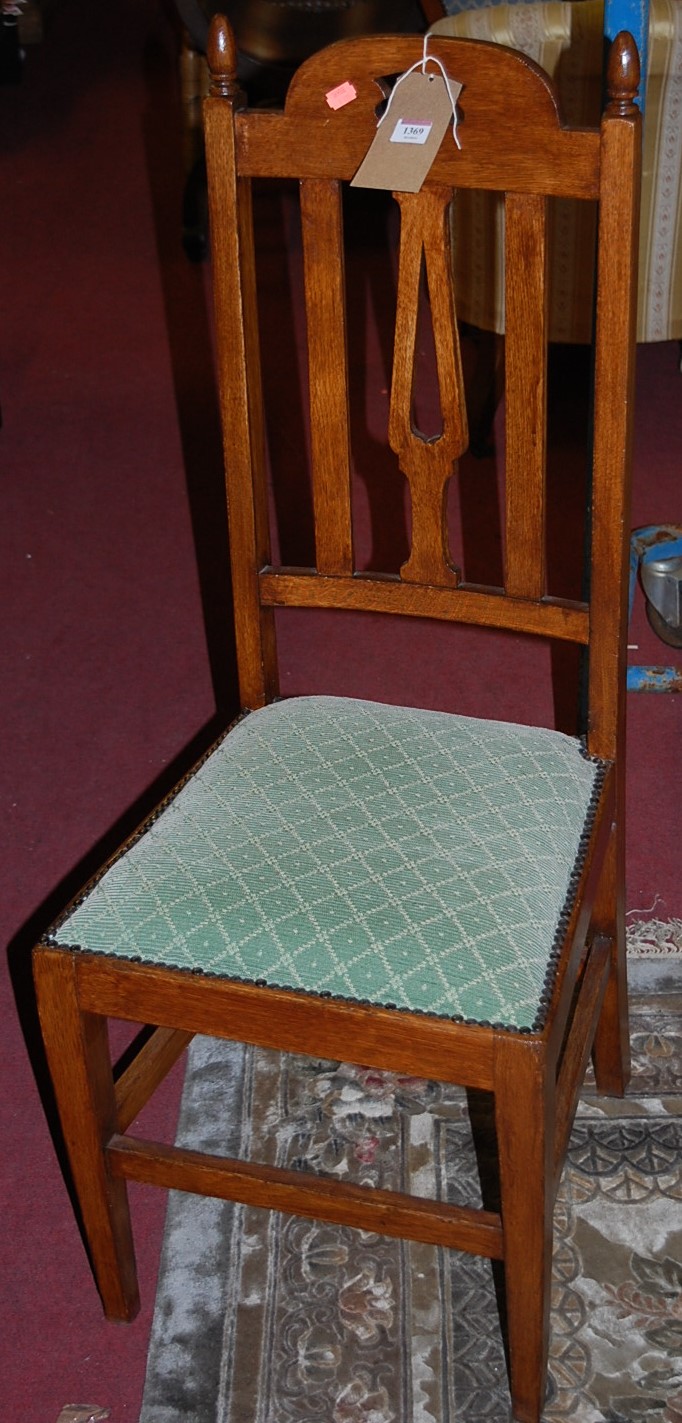 A set of six Edwardian oak slatback dining chairs, each having green fixed upholstered and studded
