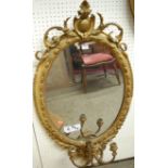 A 19th century French gilt wood and gesso oval wall mirror, having floral crested surmount with