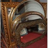 Modern gilt framed and bevelled rectangular wall mirror, two modern oval wall mirrors, an embossed