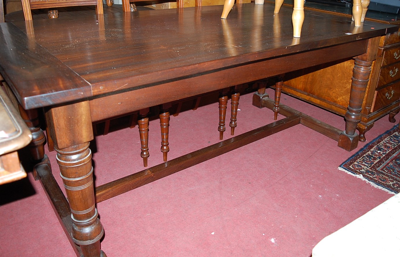 A walnut refectory table, having cleated ends and raised on ring turned and square cut supports